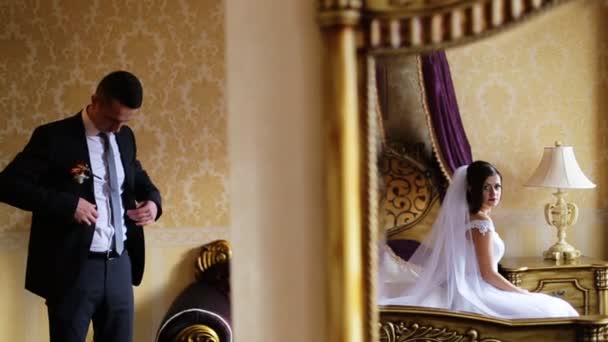 Joven lleno de emociones novia esperando hasta que su futuro esposo se prepare para una ceremonia de boda en una habitación . — Vídeos de Stock