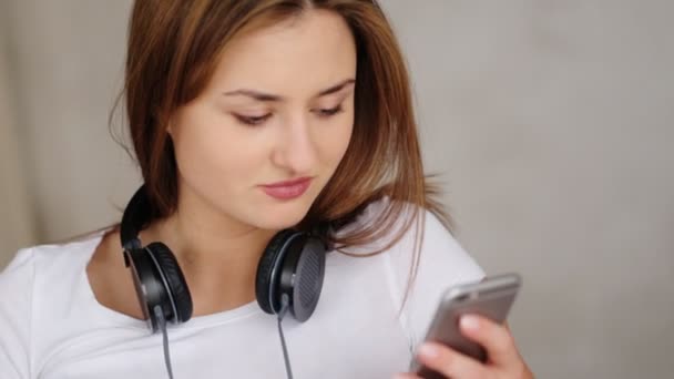 Mujer atractiva feliz escuchando música con auriculares en movimiento de baile sobre fondo blanco . — Vídeos de Stock