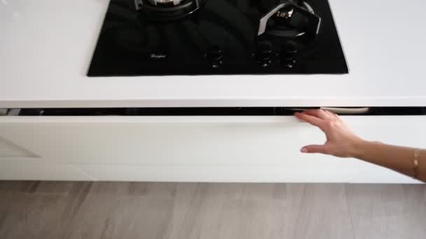 Primer plano de las manos femeninas abriendo la puerta del gabinete de la cocina y tomando el cuchillo más grande de su . — Vídeos de Stock