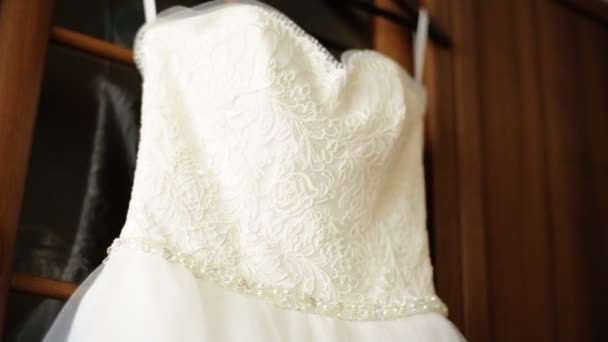 Perfect white wedding dress on hanger and fashionable shoes in the room of the bride. — Stock Video