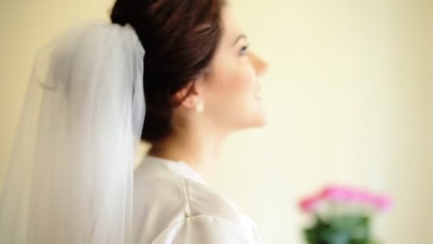 年轻可爱幸福的新娘触摸她的婚礼礼服，微笑，照相机. — 图库视频影像