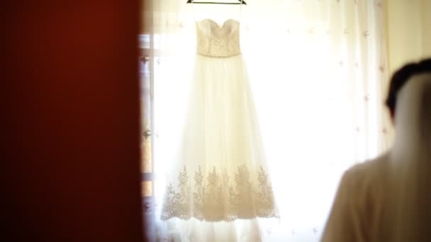 Νέοι αξιολάτρευτο ευτυχισμένη νύφη αγγίζοντας το γάμο φόρεμα και χαμογελάστε στην κάμερα. — Αρχείο Βίντεο
