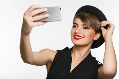 Fotoğraf stüdyosunda selfie çeken çok çekici bir genç bayanın portresi.