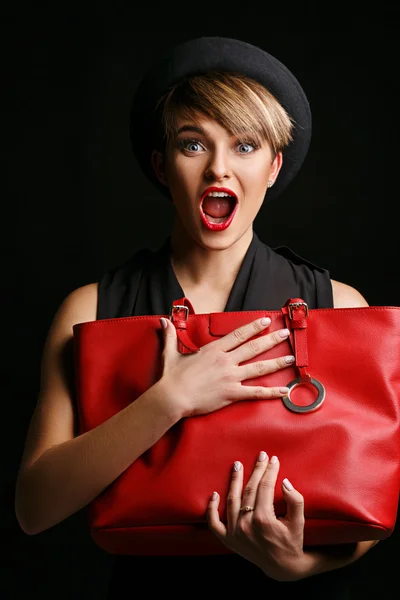 Close up of a beautiful woman with a good sense of humor , holding her  fancy red bag.