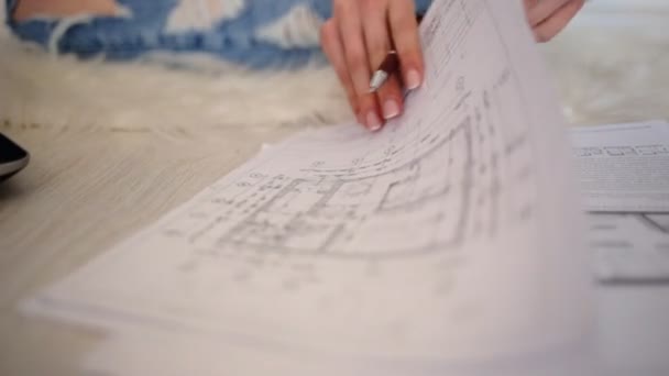 Close up of female hands with a beautiful French manicure working with diagrams. — Stock Video