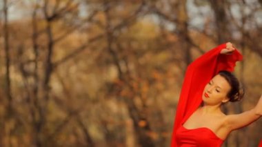 Bir parkta kamera poz uzun güzel kırmızı elbise giyen genç ciddi Bayan.