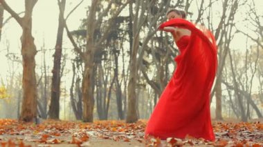 Güzel genç giyen uzun akşam kırmızı elbise profesyonel bir kameraya poz model.