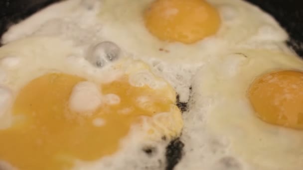 Cooking of fried eggs on stainless steel pan on gas hobfor a breakfast , simple meal to cook for a loved one. — Stock Video