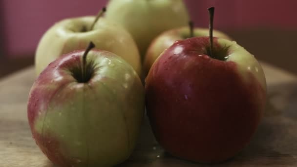 Manzanas frescas sabrosas recién lavadas y todavía húmedas debido a un fondo de madera, agua . — Vídeos de Stock