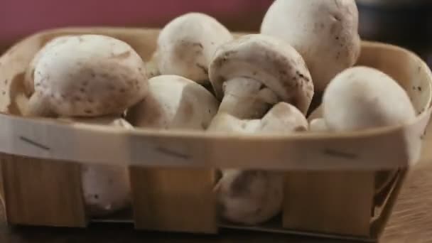 Autumn set of fresh champignons on a wooden basket left on the table at kitcken. — Stock Video