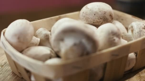 Καλάθι γεμάτο μανιτάρια champignon απομονωμένη σε ένα ξύλινο υπόβαθρο. — Αρχείο Βίντεο