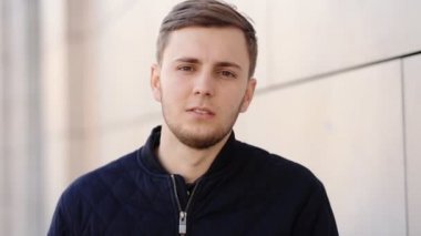 Genç yakışıklı adam kameraya poz utangaç ama yine de o fotoğraf manken olmak ve gülümsemeye çalışır.