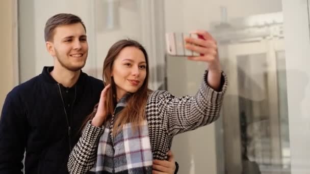 Όμορφη ελκυστική χαμογελαστή γυναίκα λαμβάνοντας selfies με ωραίο το φίλο της στο τηλέφωνό της. — Αρχείο Βίντεο