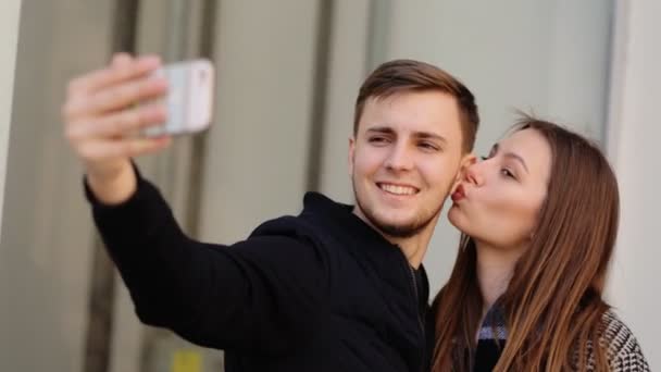 Güzel çekici gülümseyen kadın yakışıklı erkek arkadaşı ile onun telefonunda selfies alarak. — Stok video