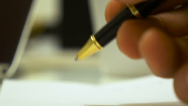 Main masculine commence à écrire un texte sur un papier à l'aide d'un stylo à bille, macro shot . — Video