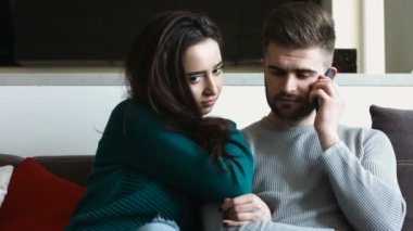 Genç güzel kadın cep telefonda konuşurken yakışıklı erkek süre sıkılmış duygusudur.