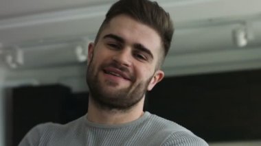 Genç çekici adam gri gözleri doğrudan bir kameraya bakıyor.