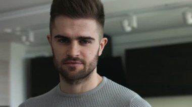 Genç çekici adam gri gözleri doğrudan bir kameraya bakıyor.