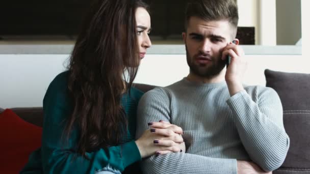 Junge schöne Frau langweilt sich, während ihr schöner Freund auf dem Handy spricht. — Stockvideo