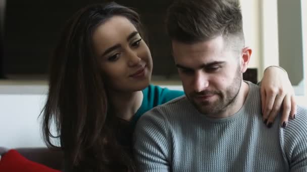Jeune femme et son beau petit ami attrayant se reposant à la maison ensemble . — Video