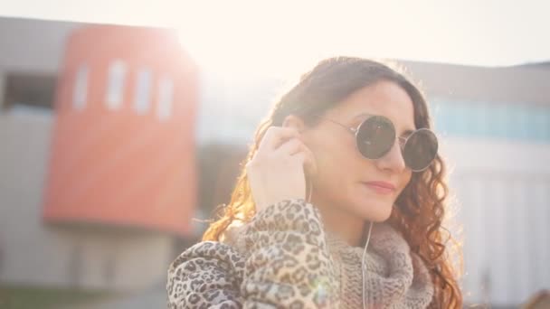 Jolie jeune femme écoutant de la musique sur son téléphone dans la rue . — Video