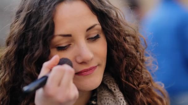 Joven sexy mujer aplicando maquillaje en su cara en la calle . — Vídeos de Stock