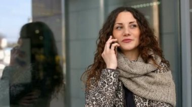 Genç çekici kadın sokakta cep telefonunda söz.