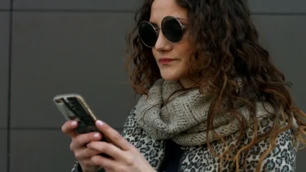 Mujer joven con gafas de sol feliz de recibir un mensaje de su novio . — Vídeo de stock