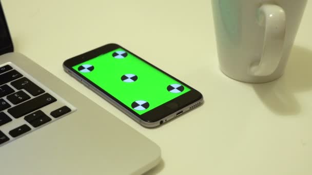 Smartphone ligt op een bureau met Chromakey op een scherm — Stockvideo