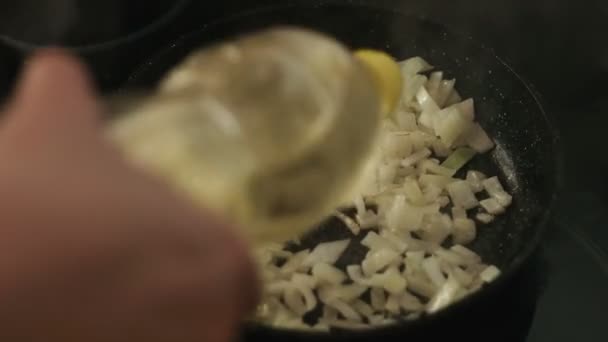 Adding oil to sliced onion to a frying pan — Stock Video