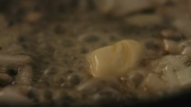 Processus de fusion du beurre sur une poêle chaude avec des oignons grillés 