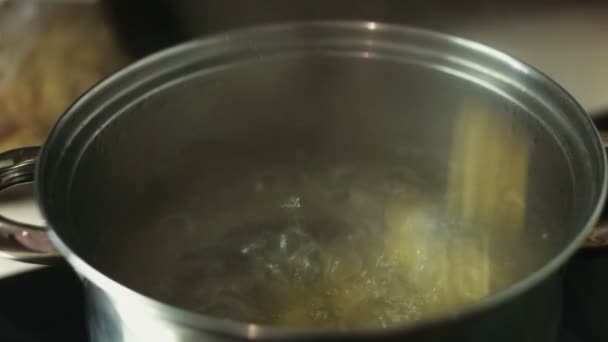 Pasta espiral hirviendo en el agua en una olla de metal — Vídeos de Stock