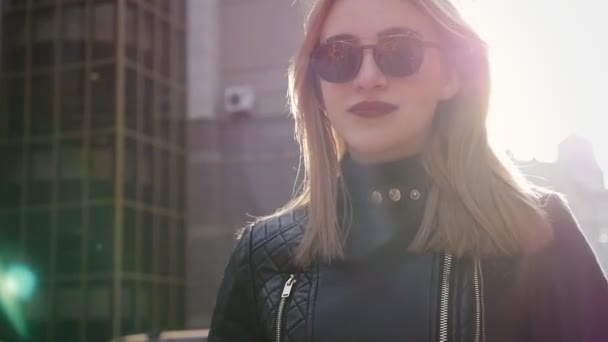 Schöne blonde junge Frau, die auf der Straße geht — Stockvideo
