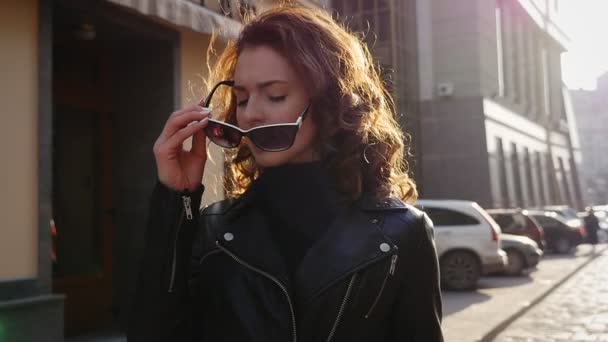 Schöne brünette junge Frau zu Fuß auf der Straße — Stockvideo