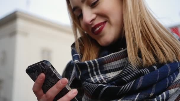 Досить молода блондинка надсилає повідомлення на свій телефон . — стокове відео
