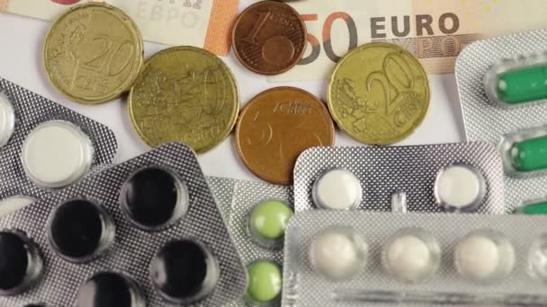 Olika Euro pengar räkningar på piller och färgglada medicin — Stockvideo