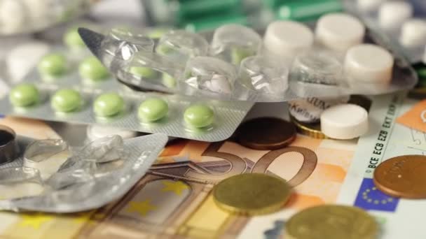 Geneeskunde pillen of capsules met geld en spuit op witte achtergrond. Apotheek business, drug kosten. Contante valuta, dure bill. Financiën concept van farmaceutische medicatie. Euromunten. — Stockvideo