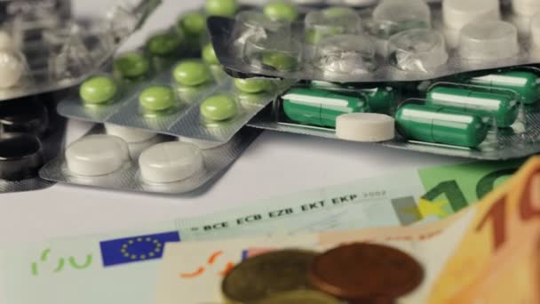 Geneeskunde pillen of capsules met geld en spuit op witte achtergrond. Apotheek business, drug kosten. Contante valuta, dure bill. Financiën concept van farmaceutische medicatie. Euromunten. — Stockvideo