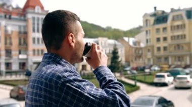 Young man outdoors with coffee