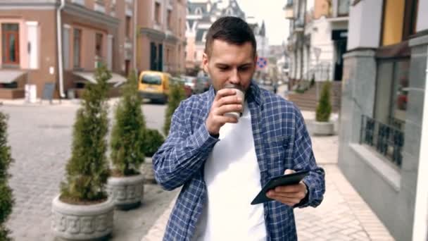 Młody człowiek przy użyciu komputera typu tablet na ulicy — Wideo stockowe