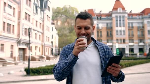 젊은이 거리에서 커피를 마시는 및 태블릿 컴퓨터를 사용 하 여 — 비디오