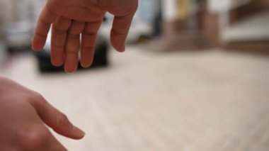 Genç bir çift el ele tutuşarak ayrıntılı görünümünü. Onlar şehir sokak yürüyüş