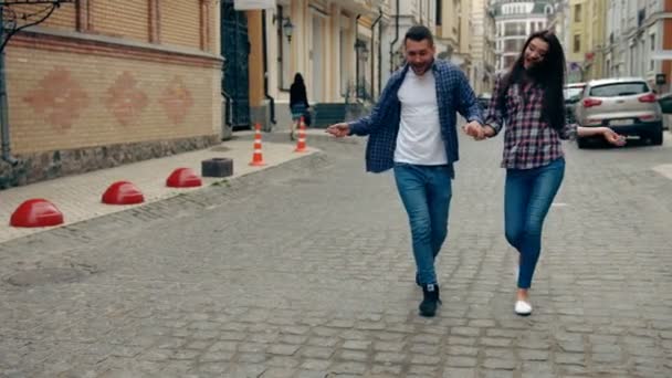 Fotografía en cámara lenta de una joven pareja bailando por la calle hacia la cámara . — Vídeos de Stock