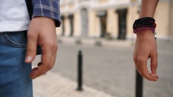 Gedetailleerde weergave van een jong koppel hand in hand. Ze wandelen in de stad straat — Stockvideo