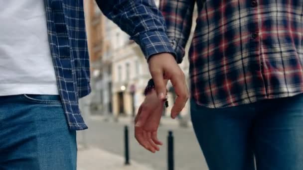 Una linda pareja camina por la calle tomados de la mano. Primer plano. . — Vídeos de Stock