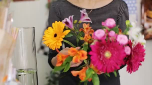 Uma mulher que trabalha como florista fazendo buquê na loja . — Vídeo de Stock