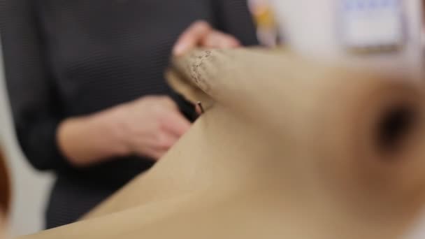 Vrouw snijden papier voor een boeket decoratie. — Stockvideo