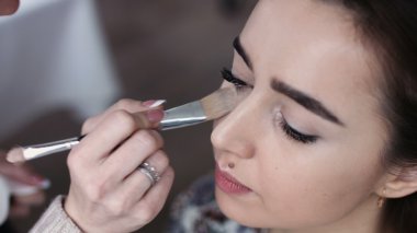 Sevimli bir model onun Çekimden önce giy makyaj alır. Atış kapatın