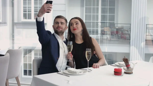 restoranda bir akıllı telefon ile mizahi bir selfie alarak Çift