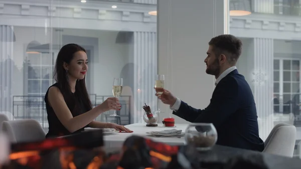 Unga lyckliga amorösa par med glas champagne på romantisk dag på restaurang — Stockfoto